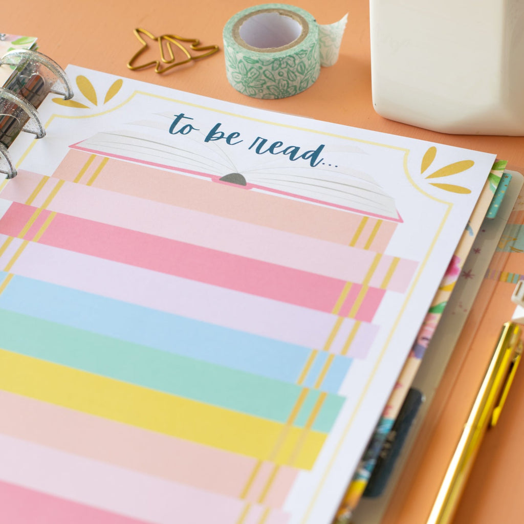 Notebook with colorful striped pages and 'to be read' label on a desk.