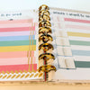 Planner with colorful stickers and a gold ring binder.