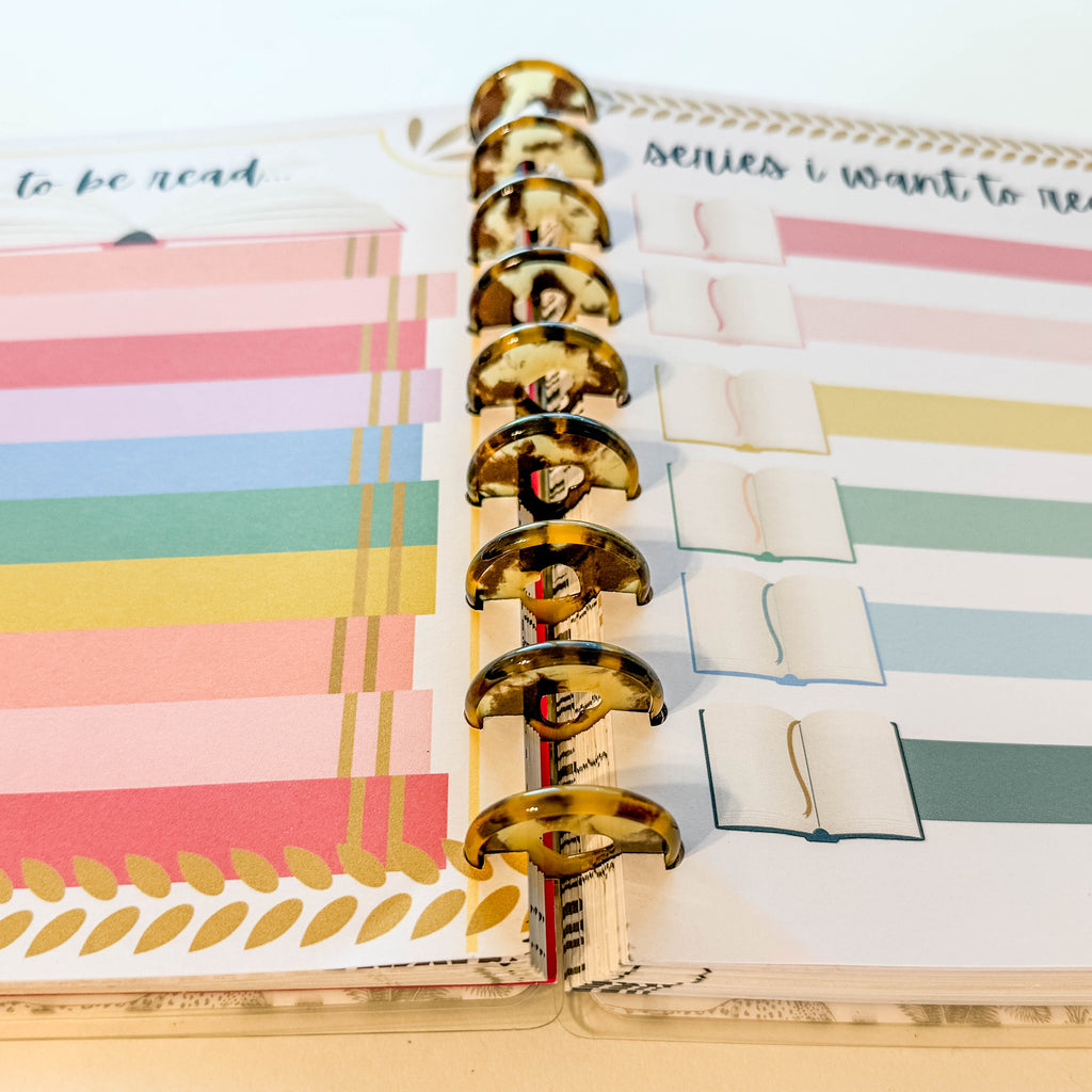 Planner with colorful stickers and a gold ring binder.