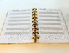 Open planner with a page titled 'books I Want to Listen To' on a light wooden surface.